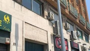 Un immeuble à plusieurs étages avec une porte verte et des unités de climatisation.