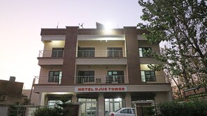 Un edificio de varios pisos con un cartel que dice 'Hotel Ojus Tower'.