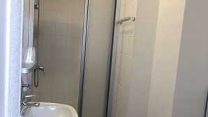 Un baño con ducha, lavamanos e inodoro.
