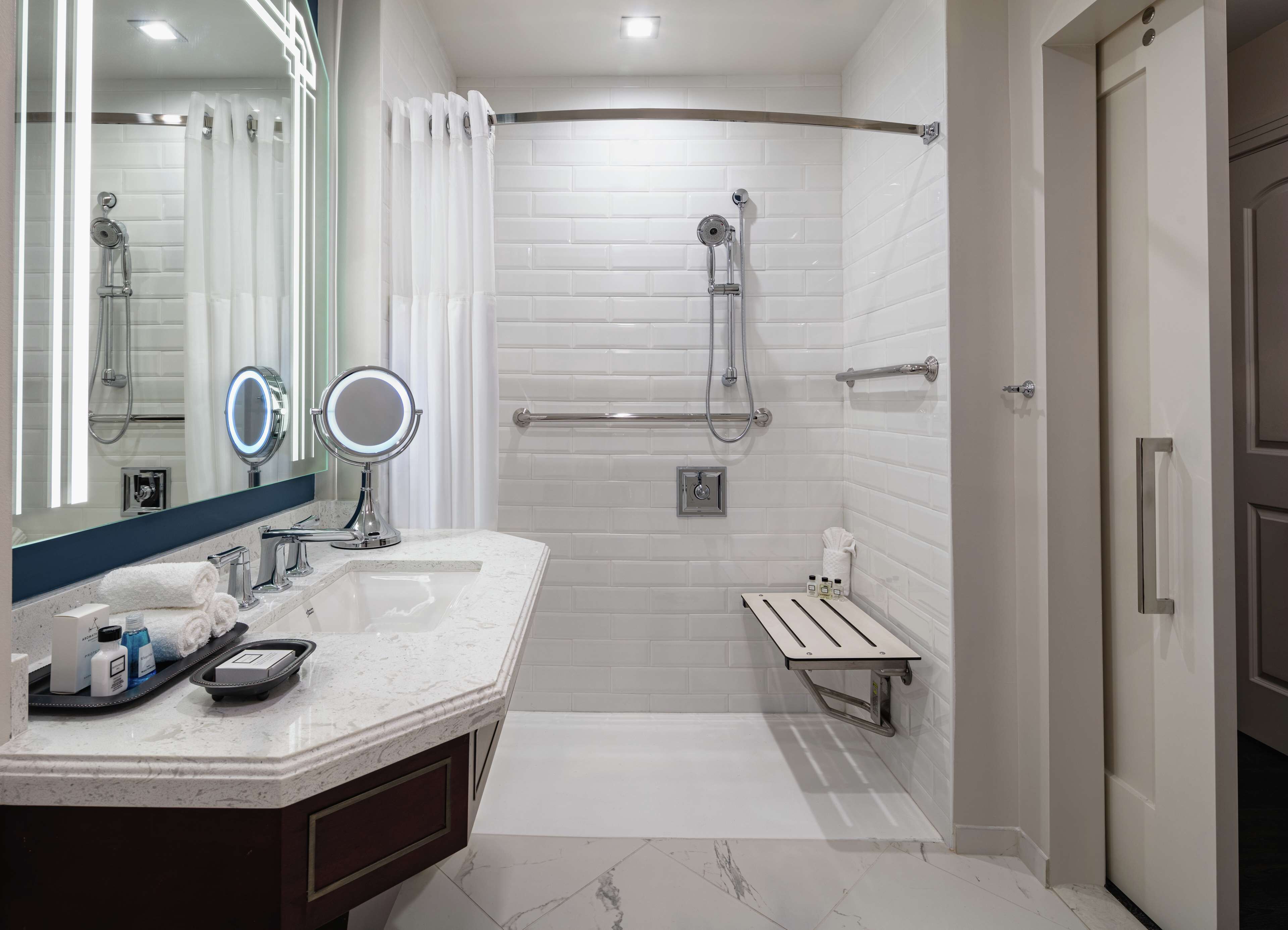 A modern bathroom with a walk-in shower, a vanity with a mirror, and a toilet.