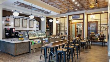 A café with a central counter, seating area, and a visible menu board.