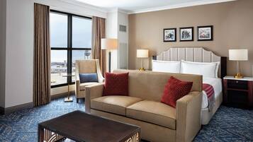 Une chambre d’hôtel avec une grande fenêtre, un canapé, un lit et une table basse.