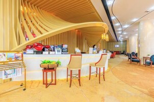 Zona de recepción con techo de madera curvada, mostrador de recepción y disposición de asientos.