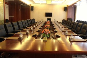 A conference room with a long table, multiple chairs, and a television screen on the wall. - Minfa World Apartment Hotel Xiangyang (Zhuge Liang Square Wanda Plaza） (XIANGYANG)