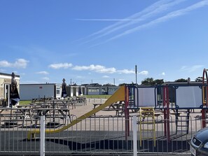 Enjoy a fun-filled day at the playground with a slide and play structures, surrounded by picnic tables and benches.