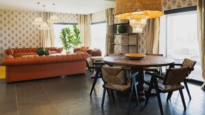 A dining area with a round table, chairs, and a large woven light fixture. - Great Villa with pool, playground, 5km to the beach Es Trenc, Campos, Mallorca (Campos)