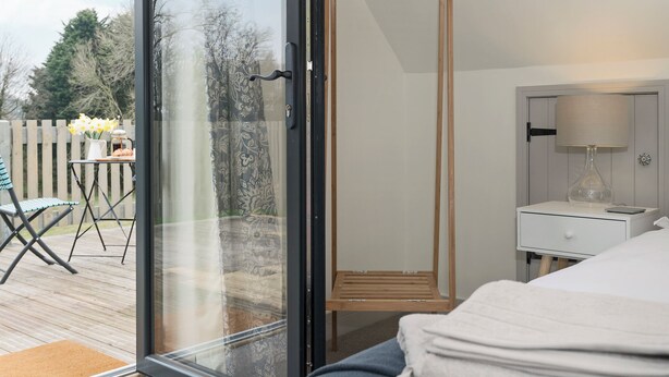 Une chambre à coucher avec un lit, une table de chevet, une lampe et une armoire en bois.