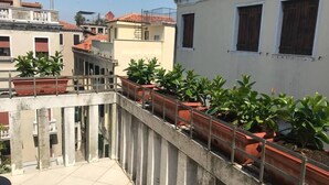 A rooftop terrace with potted plants and a tiled floor. - Le Terrazze apartment, on two floors (Unknown)