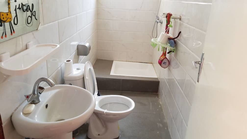 A bathroom with a sink, toilet, and shower area.