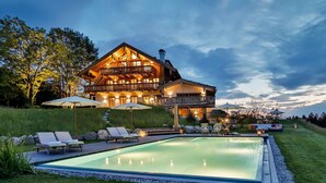 A large, two-story house with a swimming pool and outdoor seating area. - Chiemsee Chalet (Frasdorf)