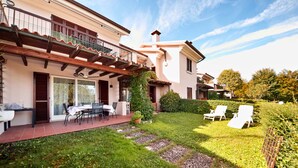 A house with a patio, outdoor seating, and a well-maintained garden. - Vista Lago (Padenghe sul Garda)