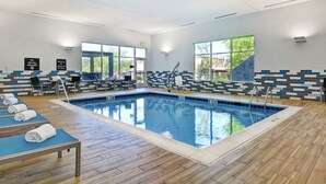 Piscina interna com espreguiçadeiras e sala de trocas.