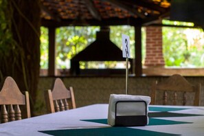 A table with a white tablecloth, a black object on it, and a sign with the number 3.