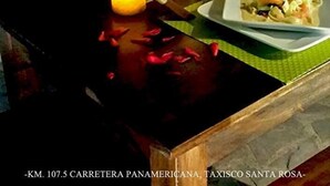 A table with a plate of food, a glass of red wine, and a candle. - Hostal Las Marias (Taxisco)