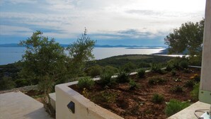 Eine Terrasse mit Blick auf das Meer und ferne Berge.