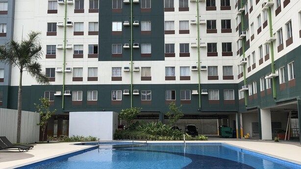 A modern apartment building with a swimming pool in the foreground. - A Home Away from Home (Mandaue City)