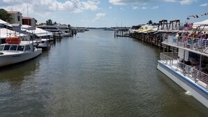 A marina with docked boats, a pier with a restaurant, and a clear sky. - Keys stilt cottage lower unit (Naples)