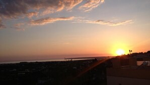 A sunset over a coastal cityscape with buildings silhouetted against the sky. - Vacation Home 2 Bedroom Luxury Home With Pool in Patroves (Albufeira)