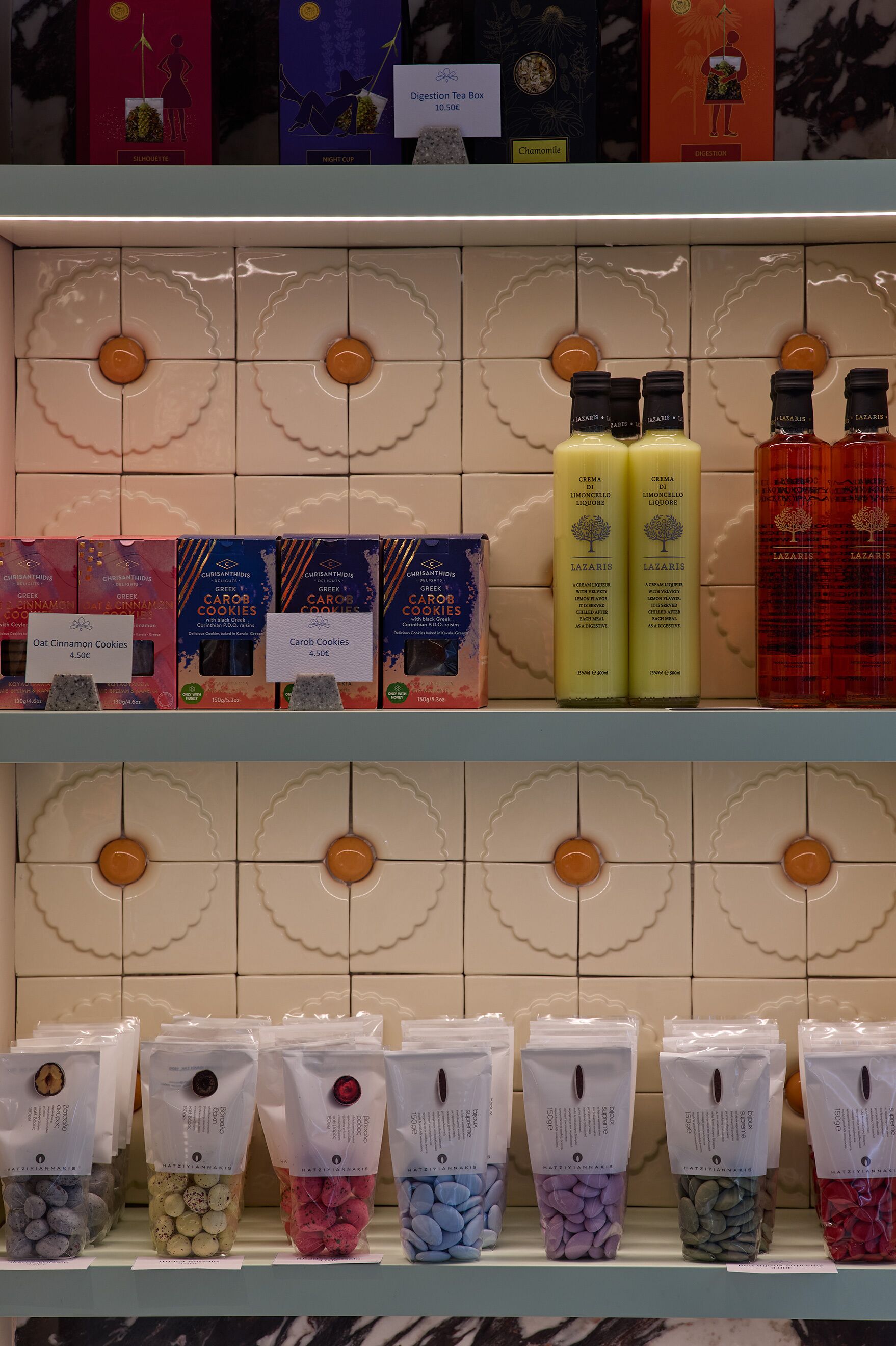 Estanteries amb galetes envasolades, espelmes i productes de bany.