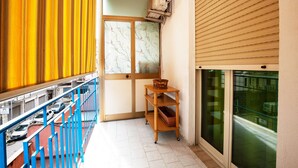 A narrow corridor with a blue railing, a wooden shelf with a basket, and a sliding door with frosted glass. - Elegant apartment located in the heart of Palermo, equipped with all comforts. (Palermo)