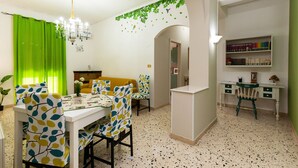 A dining area with a table and chairs, a chandelier, and a bookshelf with books. - Elegant apartment located in the heart of Palermo, equipped with all comforts. (Palermo)