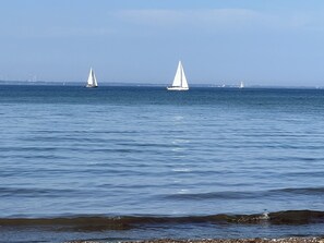 Une mer calme où voguent des voiliers.