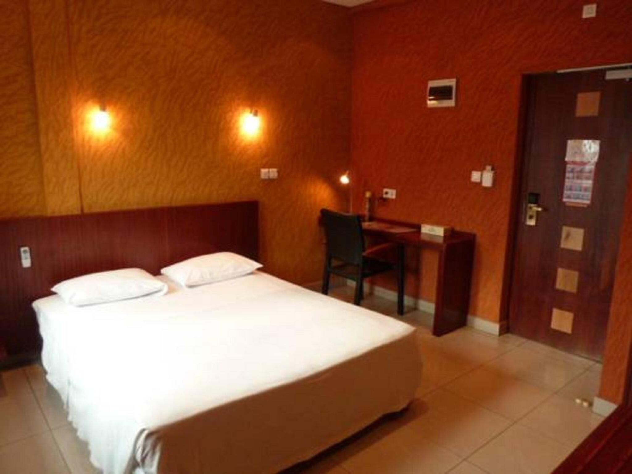 Une chambre d’hôtel avec un lit, un bureau et une chaise.