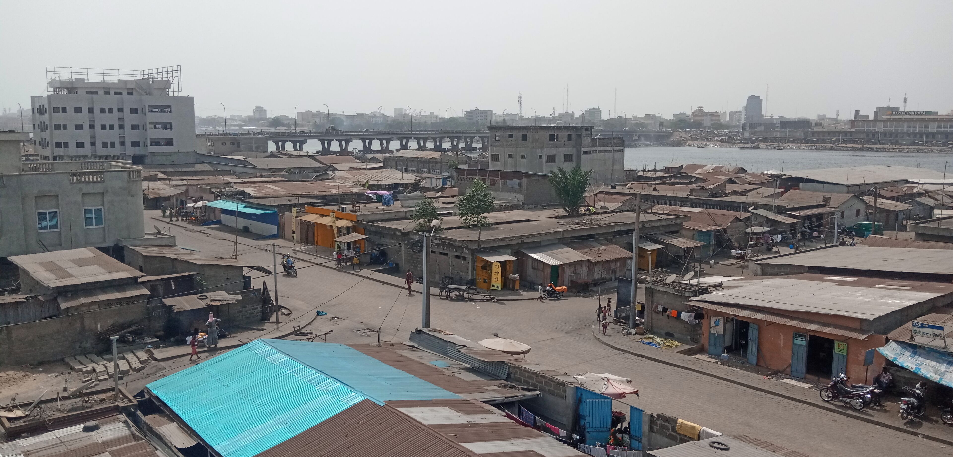 Una zona urbana densamente poblada con diversos edificios, incluida una puente al fondo.