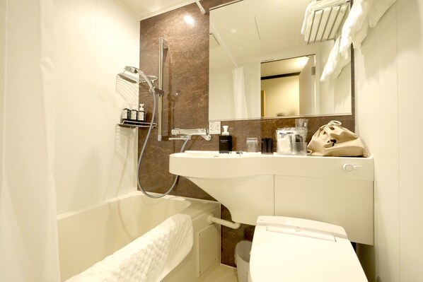 Un baño moderno con bañera, lavamanos, espejo y toallero.