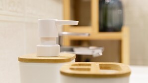 A bathroom with a white soap dispenser on a wooden tray. - Juliette Rooms (Jesi)