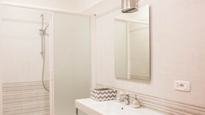 A bathroom with a shower, a sink, and a mirror. - Juliette Rooms (Jesi)