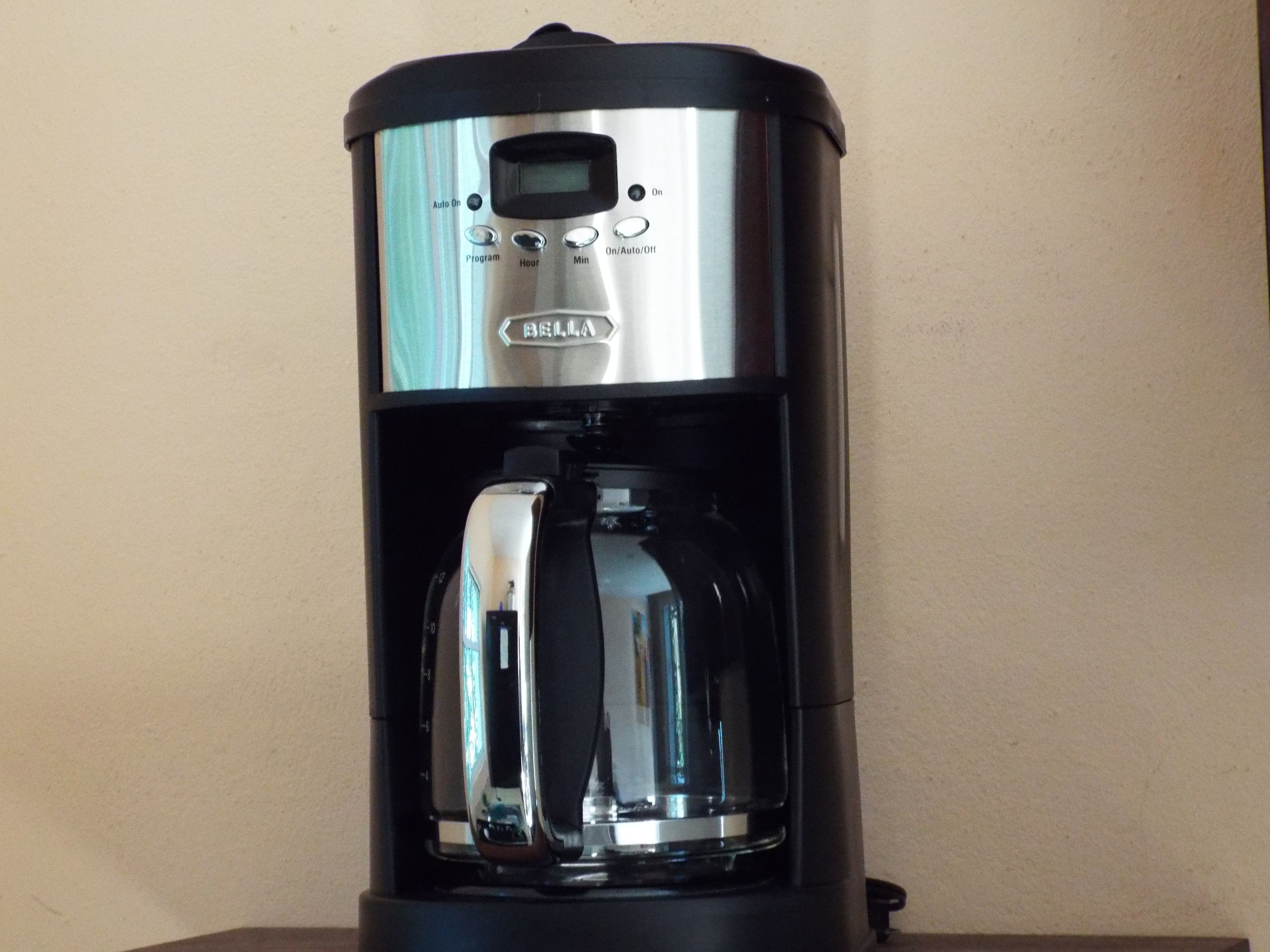 A coffee maker with a digital display and buttons for setting the program, time, and temperature.