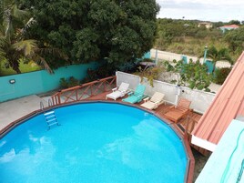 Una piscina con cubierta de madera y sillas de descanso.