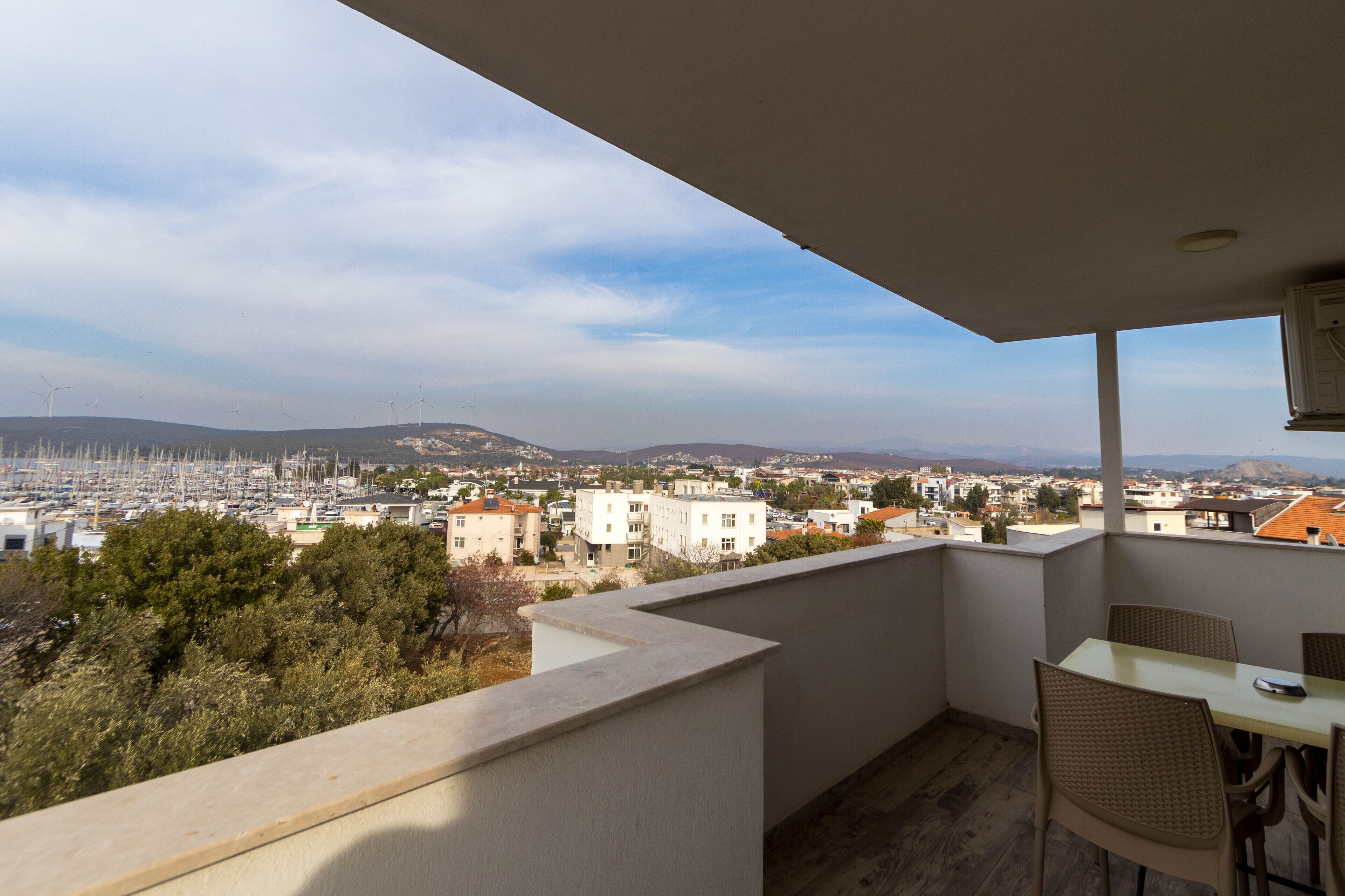 A balcony with a view of a marina and cityscape.