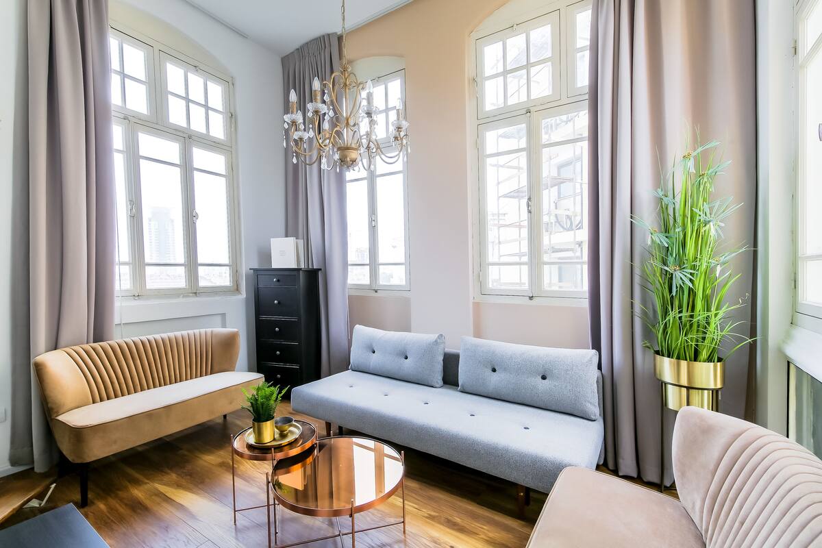 A modern living room with a sofa, a coffee table, and a potted plant.