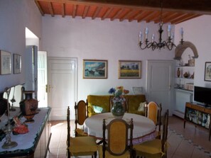 A dining area with a table set for four, surrounded by chairs. There is a chandelier above the table, and a television is visible in the background. - apartment - 6 rooms - 8/10 persons (Calci)