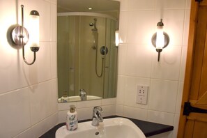 A bathroom with a white sink, a mirror, and a shower. - Rural Complex 7 Lux Cottages, Oak Cottage, Upside Down Acc, Beautiful View (Tregony)