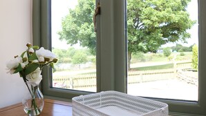 A room with a window, a white wicker basket, and a vase with white flowers. - Rural Complex 7 Lux Cottages, Beech Cottage Sleeps 2, 1 well behaved dog allowed (Tregony)