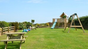 A playground with a slide, swings, and picnic tables. - Rural Complex 7 Lux Cottages, Beech Cottage Sleeps 2, 1 well behaved dog allowed (Tregony)