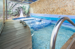 A hot tub with a wooden deck and a stone wall. - Boutique Hotel & Spa Les Vinyes - Adults Only (Montferri)