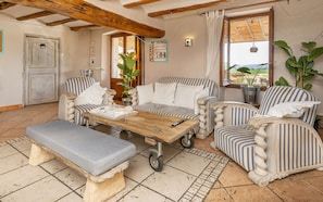 A cozy living room with striped furniture, a wooden coffee table, and a bench. - Boutique Hotel & Spa Les Vinyes - Adults Only (Montferri)