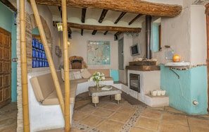 A cozy living room with a stone fireplace, a sofa, and a coffee table. - Boutique Hotel & Spa Les Vinyes - Adults Only (Montferri)