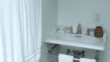 Un baño con un lavabo blanco, un espejo y un perchero para toallas.