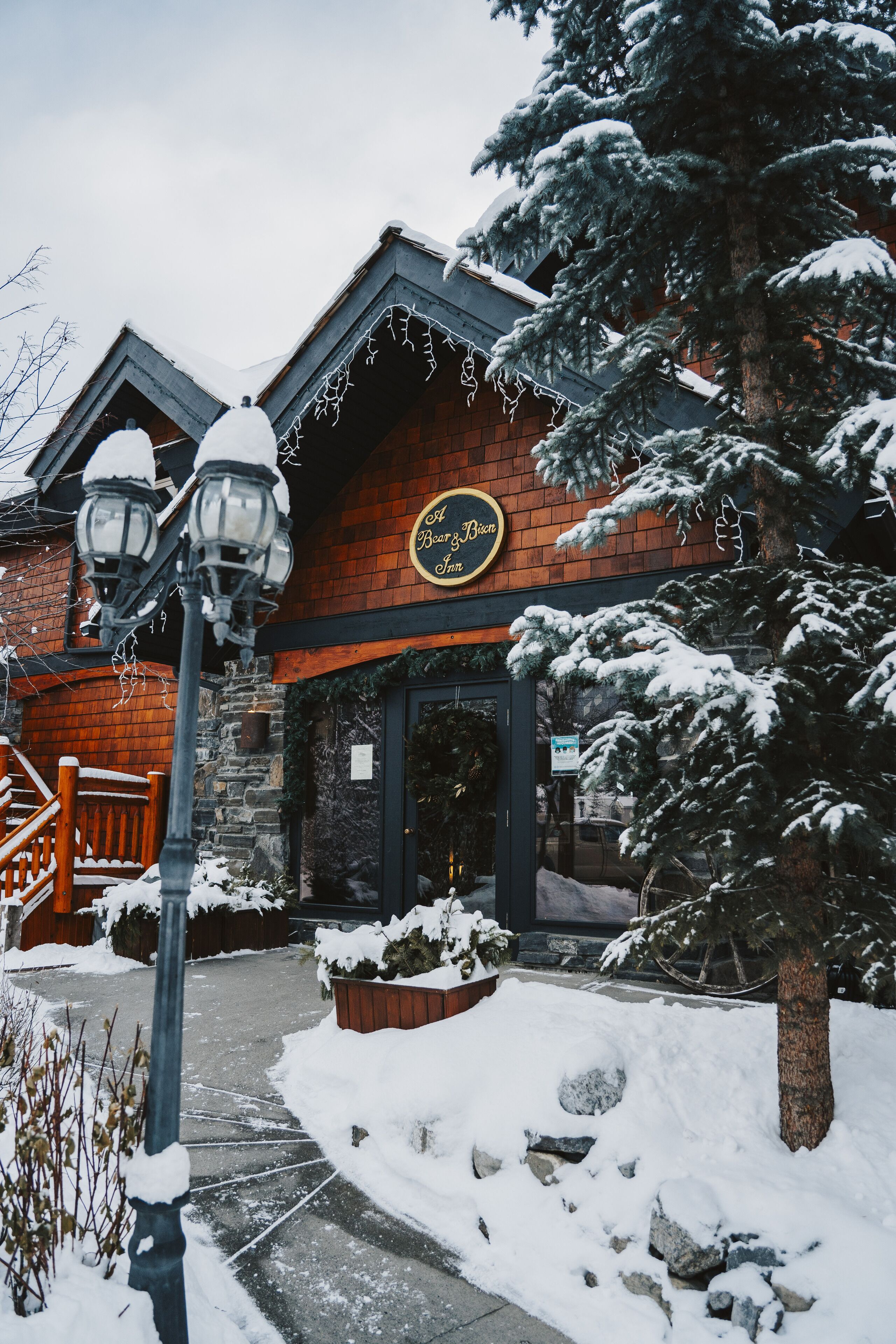 A building with a wooden facade, a sign reading "Old Bear Inn," and snow-covered surroundings.