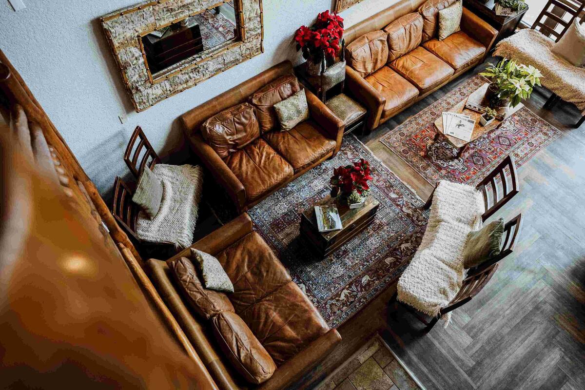A spacious living area with leather sofas, a coffee table, and a patterned rug.