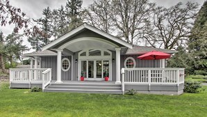 A two-story house with a covered porch, a red umbrella, and a well-maintained lawn. - Contemporary Tacoma Cottage w/ Deck & Pond! (Tacoma)