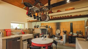 Una cocina equipada con lavavajillas, estufa, horno y utensilios colgando.