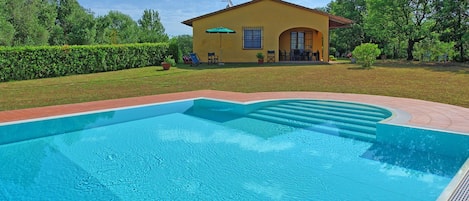 A swimming pool with a house in the background.