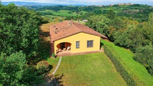 A yellow villa with a tiled roof, surrounded by lush greenery and hills. - Beautiful private villa with WIFI, private pool, TV, terrace, pets allowed and panoramic view (Legoli)