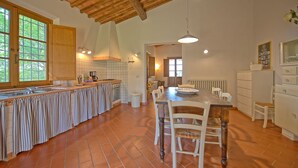 A spacious kitchen with a large island, wooden cabinets, and a tiled backsplash. - Beautiful private villa with WIFI, private pool, TV, terrace, pets allowed and panoramic view (Legoli)